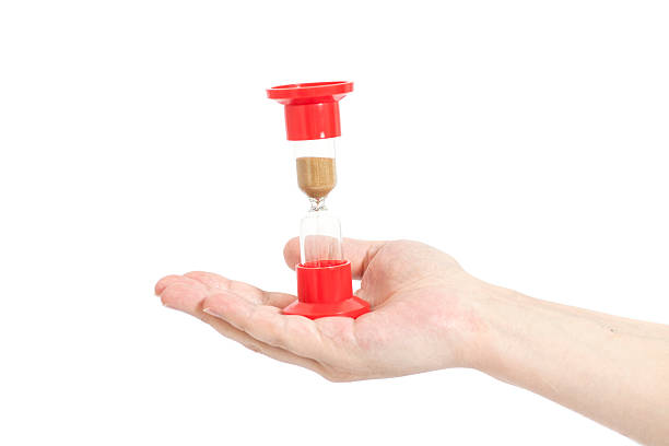 istock Man hand holding hourglass Isolated on white 511373412