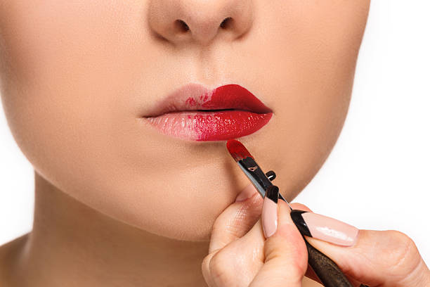 istock Beautiful female lips with make-up and brush 511373594
