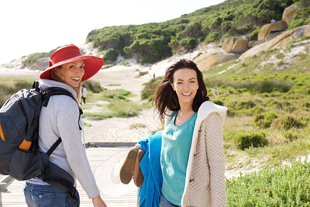 istock Two women walking to the beach with bag and clothes 511374466