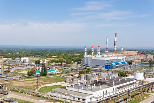 Industrial landscape of refinery at summer day through smoke