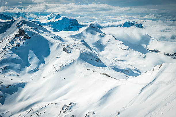 winter wonderland olas de nívea montaña picos por encima de las nubes alpes - muerren fotografías e imágenes de stock