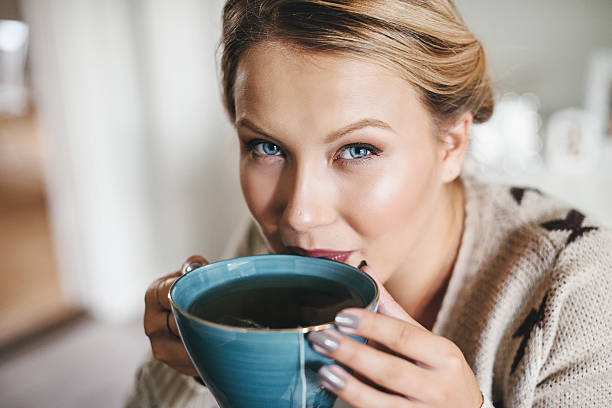 istock Woman having a cup of tea in her kitchen 511387109