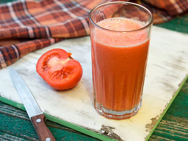 istock Fresh tomatoe and tomato juice on wooden table 511387364