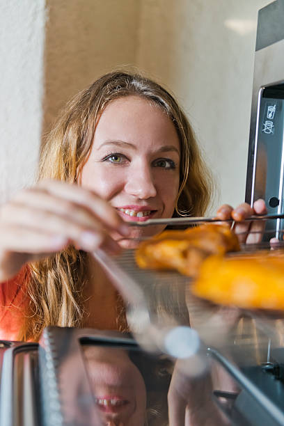 istock woman putting meat into oven 511388303