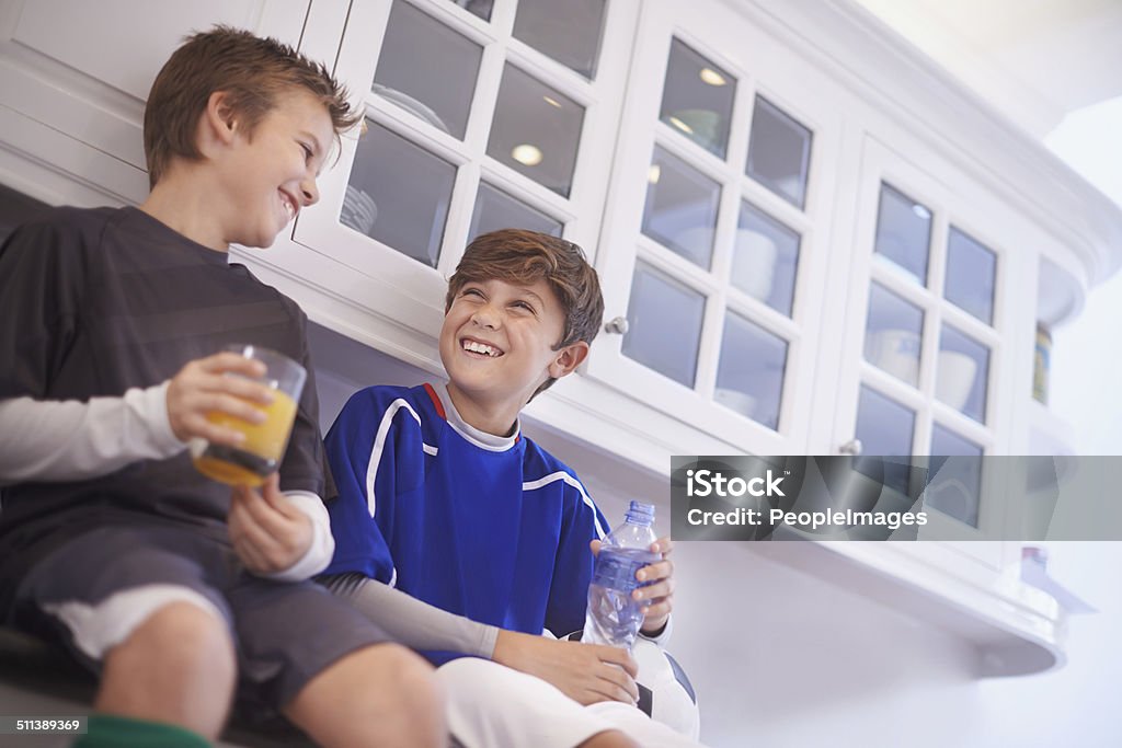 Discussing the game over some hard-earned refreshment Cropped shot of two young boys having cold drinks after soccer practice Child Stock Photo