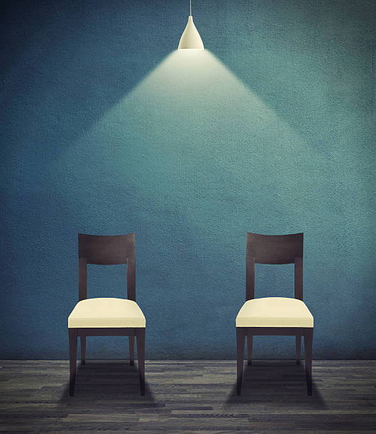 Ominously empty Illustration of two empty chairs sitting under a light bulb legs against the wall stock pictures, royalty-free photos & images