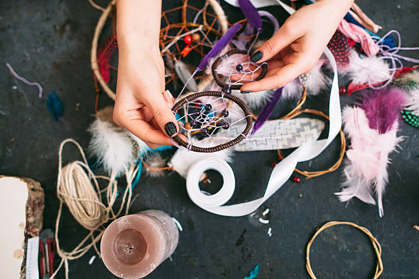 istock woman makes Dreamcatcher of sewing accessories. 511389732