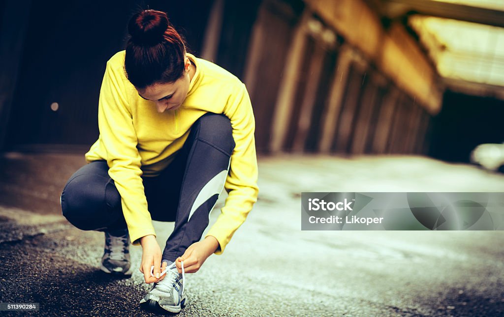 young woman preparing for a run young woman preparing for a run and tied shoelace Autumn Stock Photo