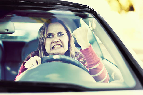istock Losing her temper, a woman driver shakes fist through windshield 511390337