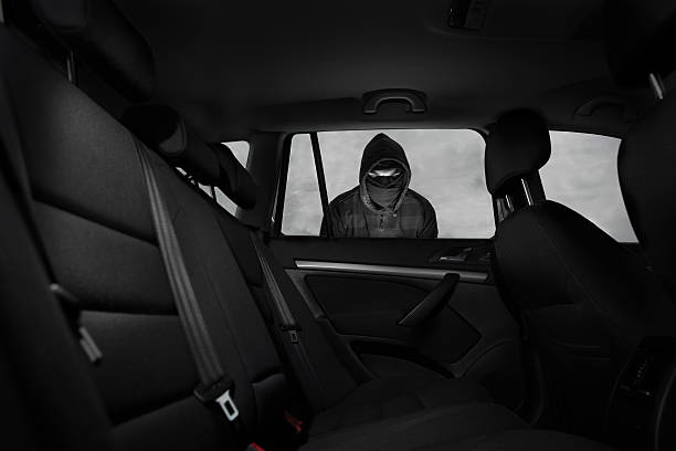 Thief in a mask hijacks the car stock photo