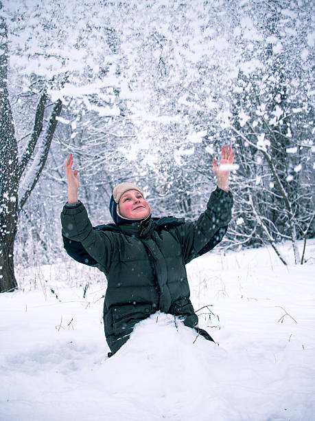 istock image of a smiling little boy during a heavy snowfall 511391410