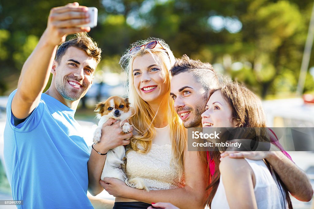 Friends with dog taking group selfie with smart phone Friends with dog taking selfie with smart phone. 14-15 Years Stock Photo