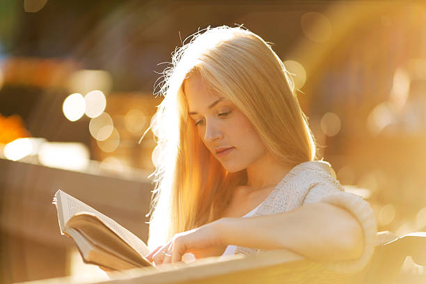istock Happy blonde girl reading a book 511392137