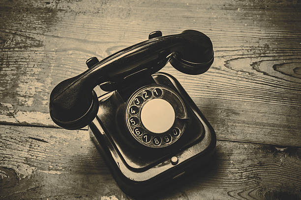 istock Old black phone with dust and scratches on wooden floor 511392328