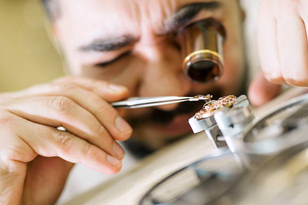 acercamiento retrato de un relojero en el trabajo - watchmaking fotografías e imágenes de stock