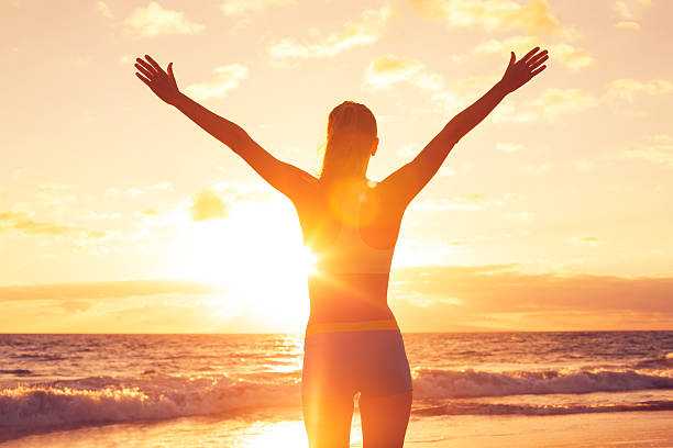 Happy Free Woman at Sunset on the Beach stock photo