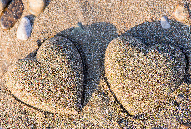 dwa piasek serce w piasku by the sea - beach love heart shape two objects zdjęcia i obrazy z banku zdjęć