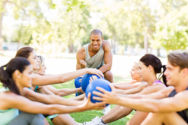 istock Instructor Motivating People Exercising With Medicine Balls 511435553