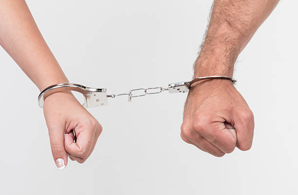 istock Man and woman's hands handcuffed together 511440309