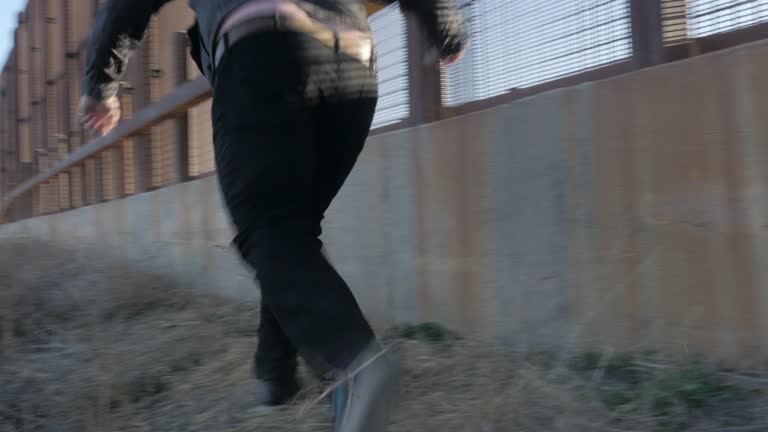 Man Hops Down Off Border Fence and Runs Alongside It