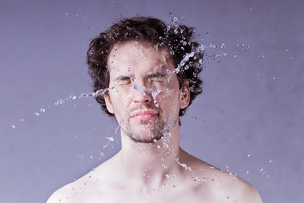 zmywanie. przystojny mężczyzna z rozbijające się wody na twarzy. - zwolnione tempo zdjęcia i obrazy z banku zdjęć