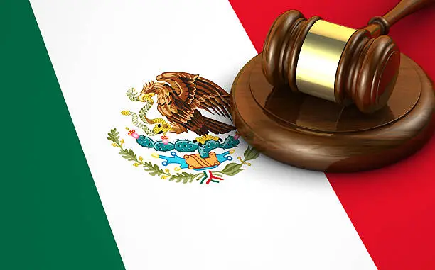 Mexico laws, legal system and justice concept with a 3d render of a gavel and the Mexican flag on background.