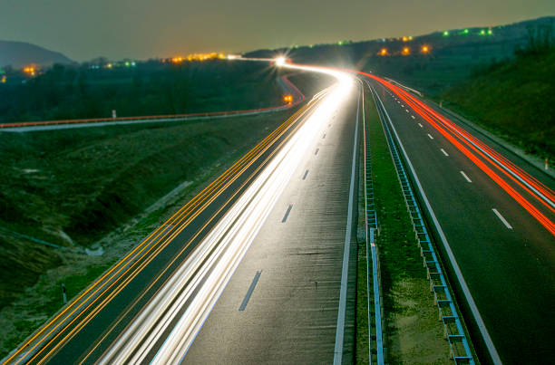 vitesse matin, flou de mouvement de trafic en l'europe - traffic blurred motion multiple lane highway night photos et images de collection