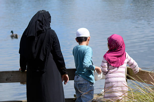Auckland, New Zealand - October 1, 2015: An Immigrant Muslim family feeds ducks in a pond. New Zealand will take 750 Syrian refugees over the next 3 years after pressure to respond to the humanitarian crisis in Europe.