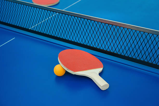 istock pingpong rackets and ball and net on pingpong table 511466418