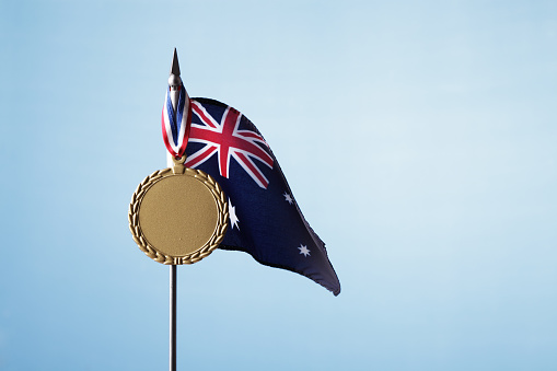 Australian flag with gold medal against blue sky