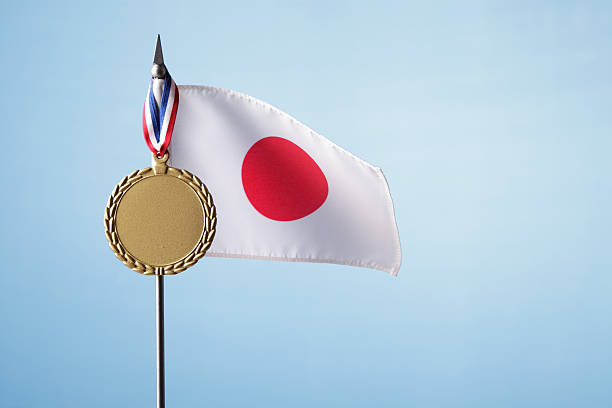 Japanese flag with gold medal against blue sky
