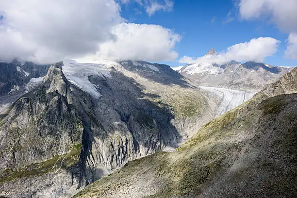 The massif of the mountain Gross Wannenhorn (3.906 m, the peak is behind the clouds) is located on the left side of the picture. The Fiescher Glacier (German: Fieschergletscher) is visible on the right side. It is the 3rd largest glacier in the European Alps. The mountain Finsteraarhorn (4274 m) is situated in the background right. The picture was taken from the mountain Risihorn (2926  m).