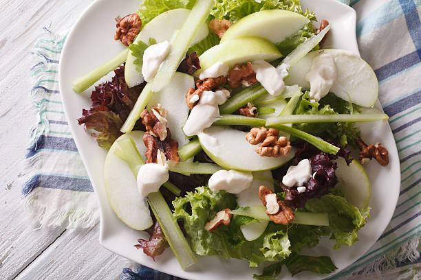 Healthy Waldorf Salad close-up on a plate. Horizontal top view Healthy Waldorf Salad close-up on a plate on the table. Horizontal view from above green apple slice overhead stock pictures, royalty-free photos & images