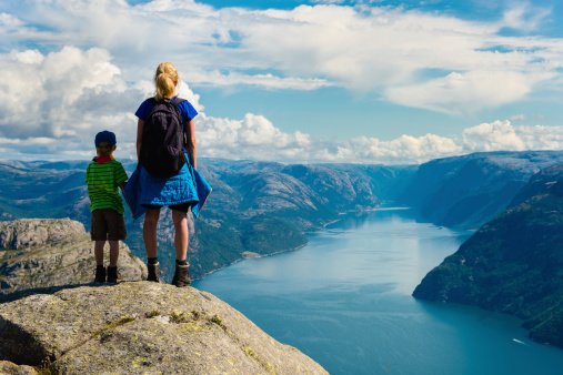 mother and child looking down to Lysefjorden in Norway. Near famous Preikestolen , Pulpit Rock.