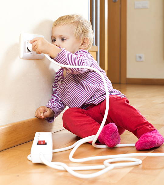 istock Baby girl playing with electrical extension 511474899