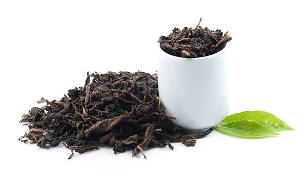 istock Black tea with green leaf isolated on white 511475579