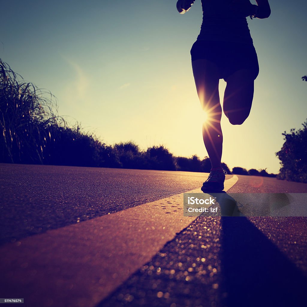 young fitness woman runner running on sunrise seaside road Active Lifestyle Stock Photo