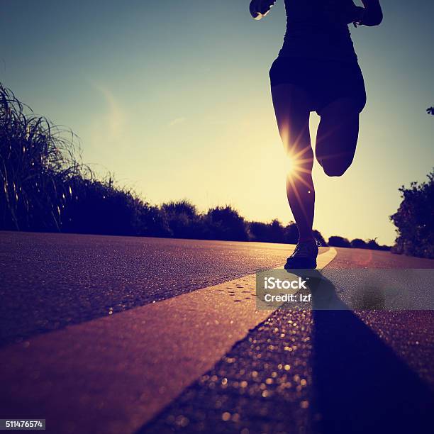 Young Fitness Woman Runner Running On Sunrise Seaside Road Stock Photo - Download Image Now