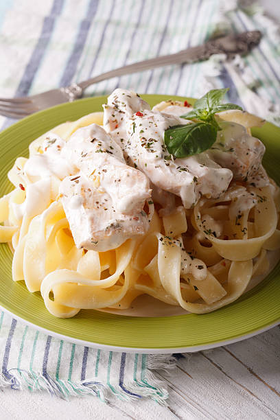 istock Pasta Alfredo with chicken and cream sauce close-up. Vertical 511477648