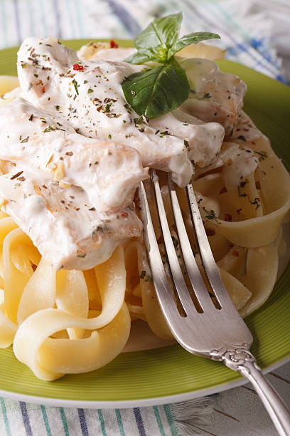 istock fettuccine pasta with chicken and cream sauce close-up. vertical 511478556
