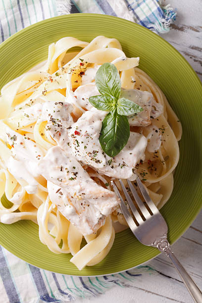 istock fettuccine alfredo pasta with chicken closeup. vertical top view 511478804