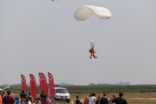De Cocksdorp, The Netherlands - August 2, 2014: Visitors of the Para centre Texel are watching the landing of a parachutist on the field in front of the centre.