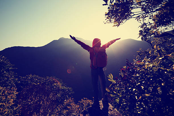 istock successful woman hiker open arms on sunrise mountain peak 511479264