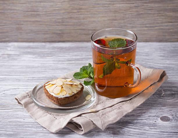 istock Mint tea and cake with cream and almond petals 511479768