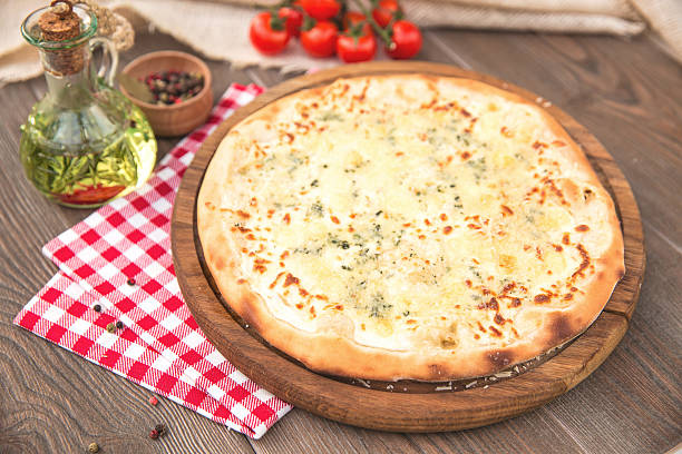 istock Italian Pizza quattro fromaggi on a wooden board 511481752