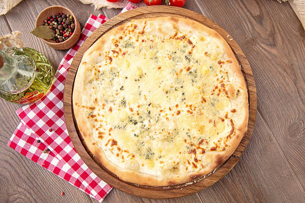 istock Italian Pizza quattro fromaggi on a wooden board 511481832