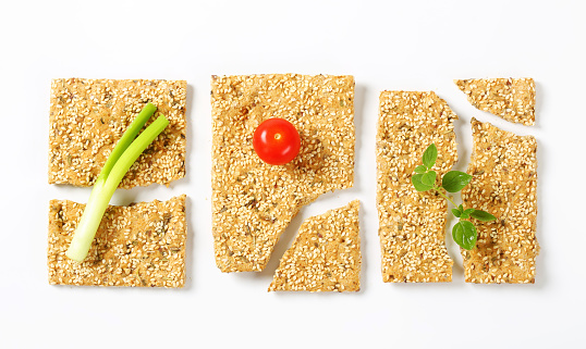Whole wheat crackers with sesame seeds and chopped herbs
