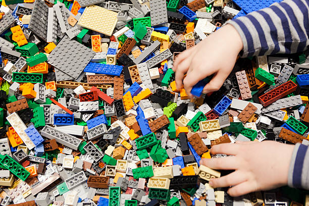 남자아이 놀이-더미 색상화 Lego 벽돌. 스톡 사진