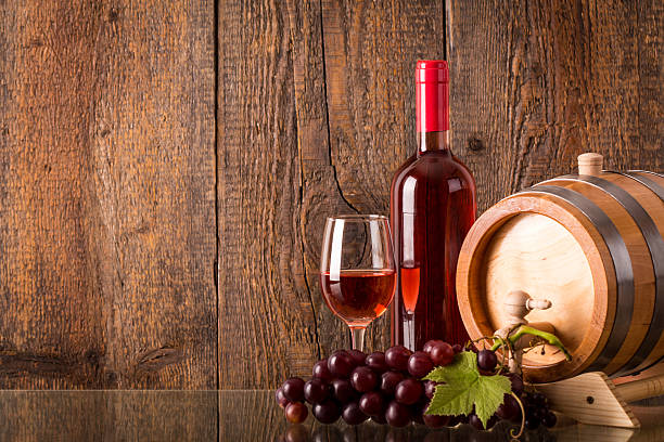 Glass of rose wine with bottle barrel grapes stock photo