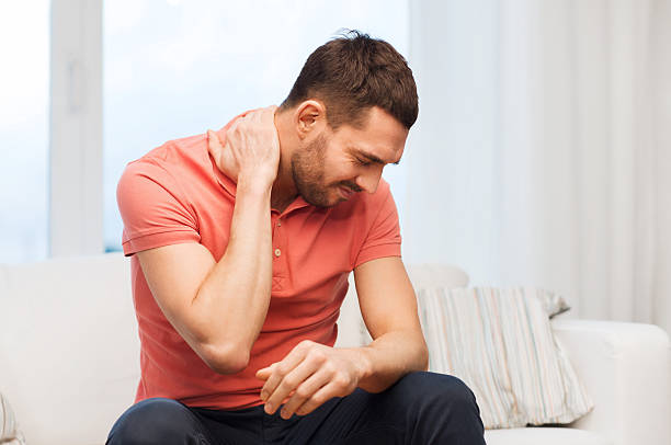 istock unhappy man suffering from neck pain at home 511484604